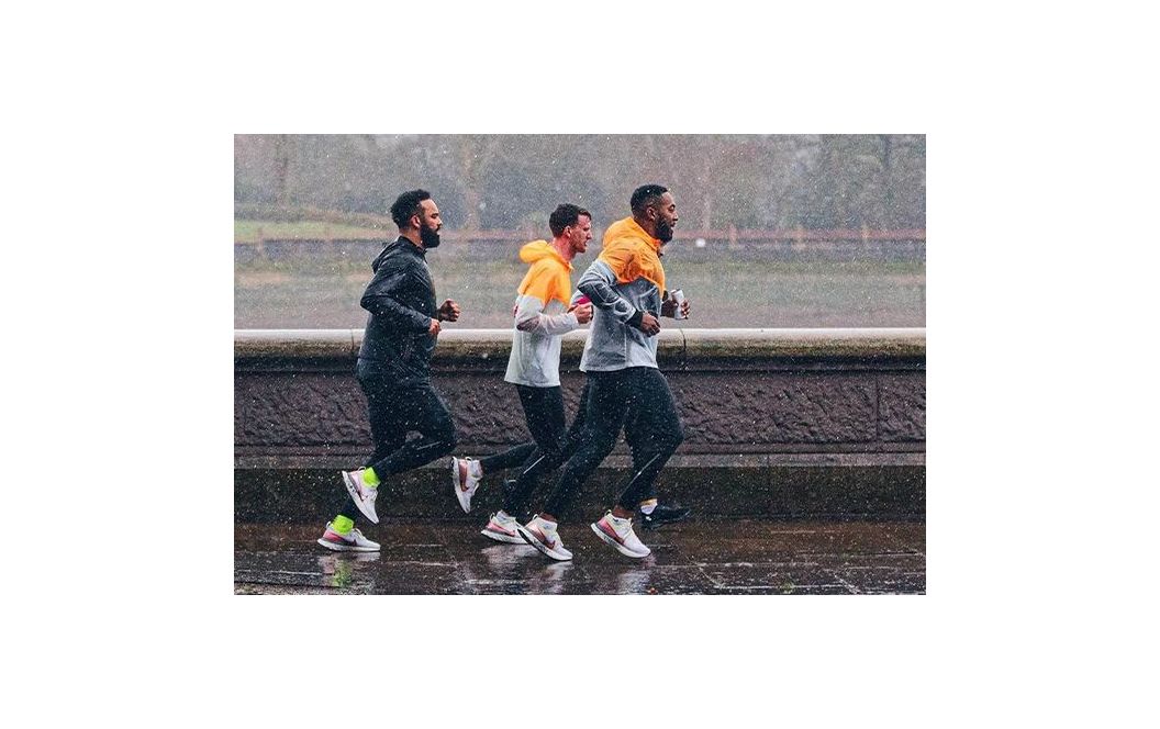 Trois hommes qui courent sous la pluie