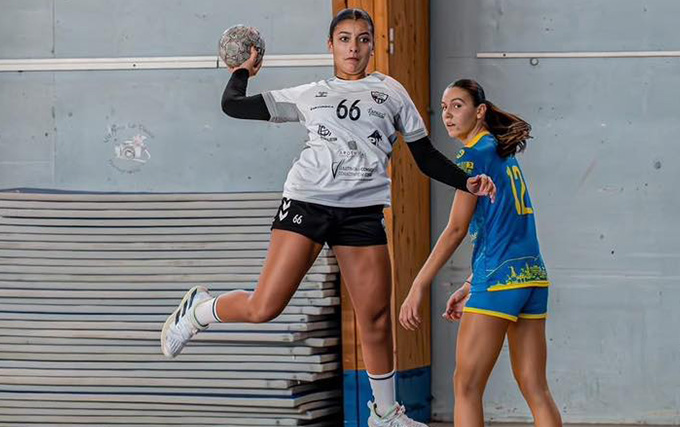 Joueuse de handball en blanc qui s'apprête à tirer